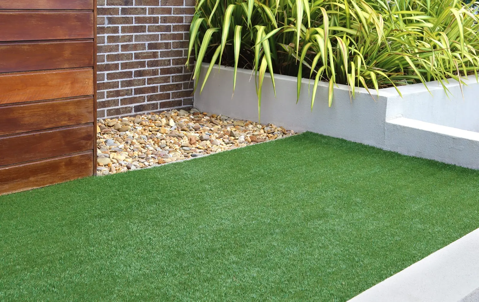 Artificial grass lawn in a garden with paving