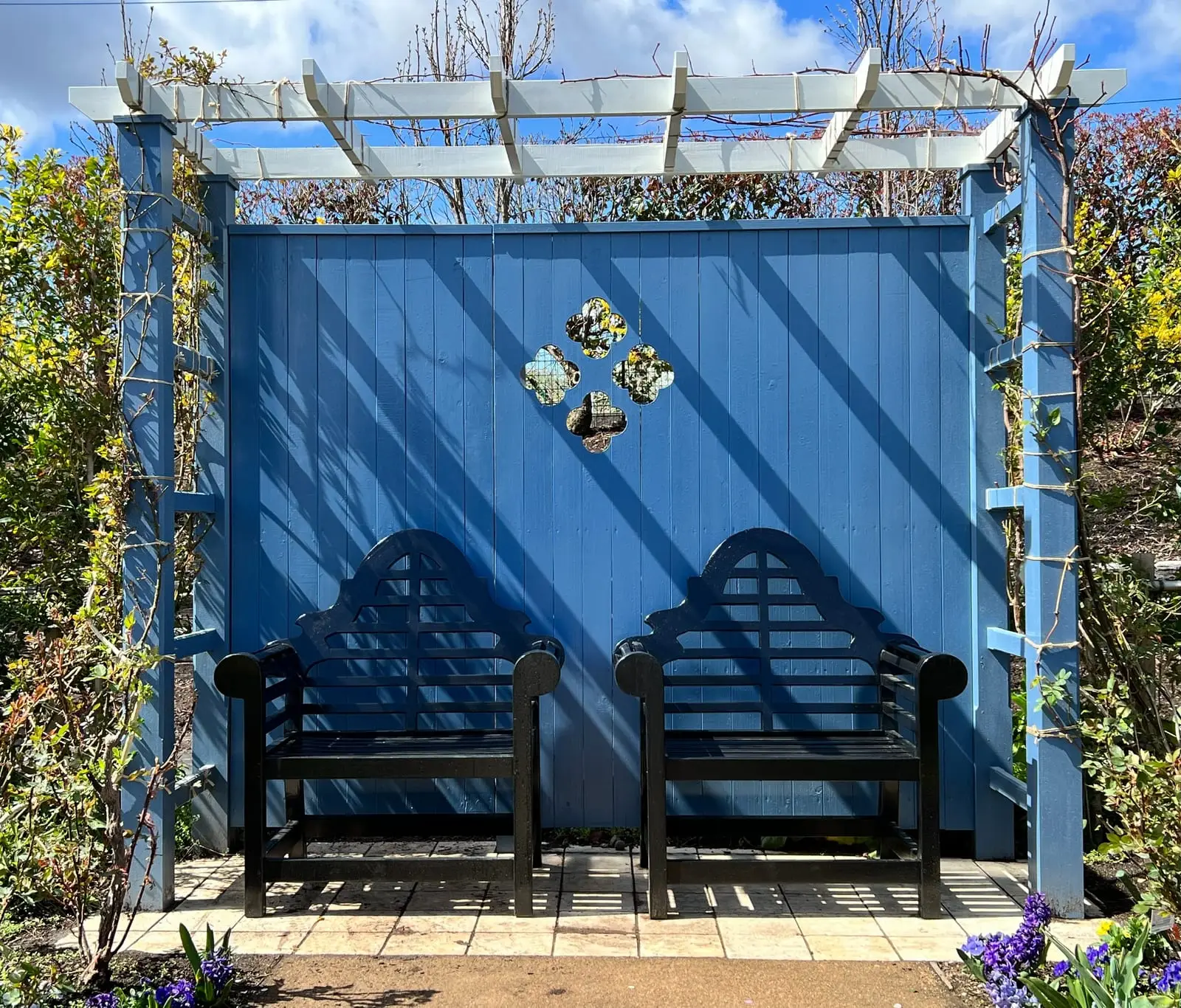 Painted timber pergola arbour over garden benches