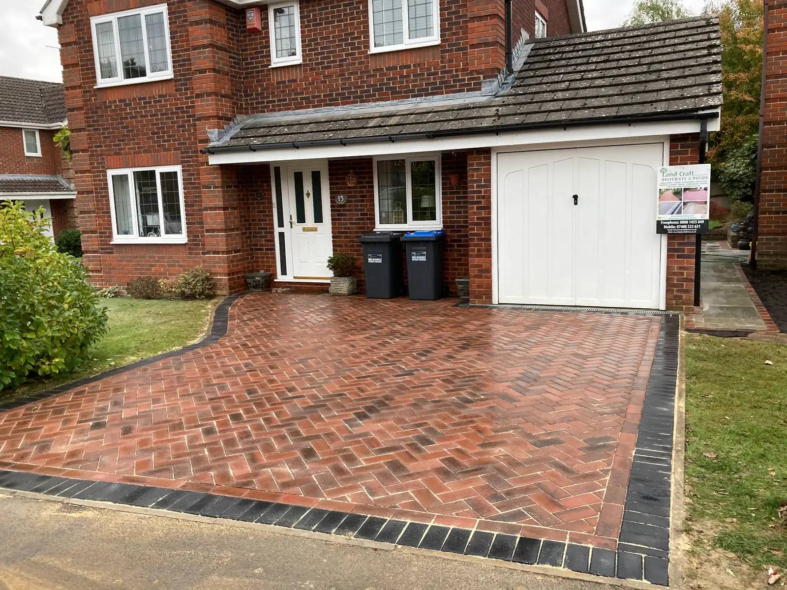 Red herringbone block paved driveway in front of a detached house in Sussex
