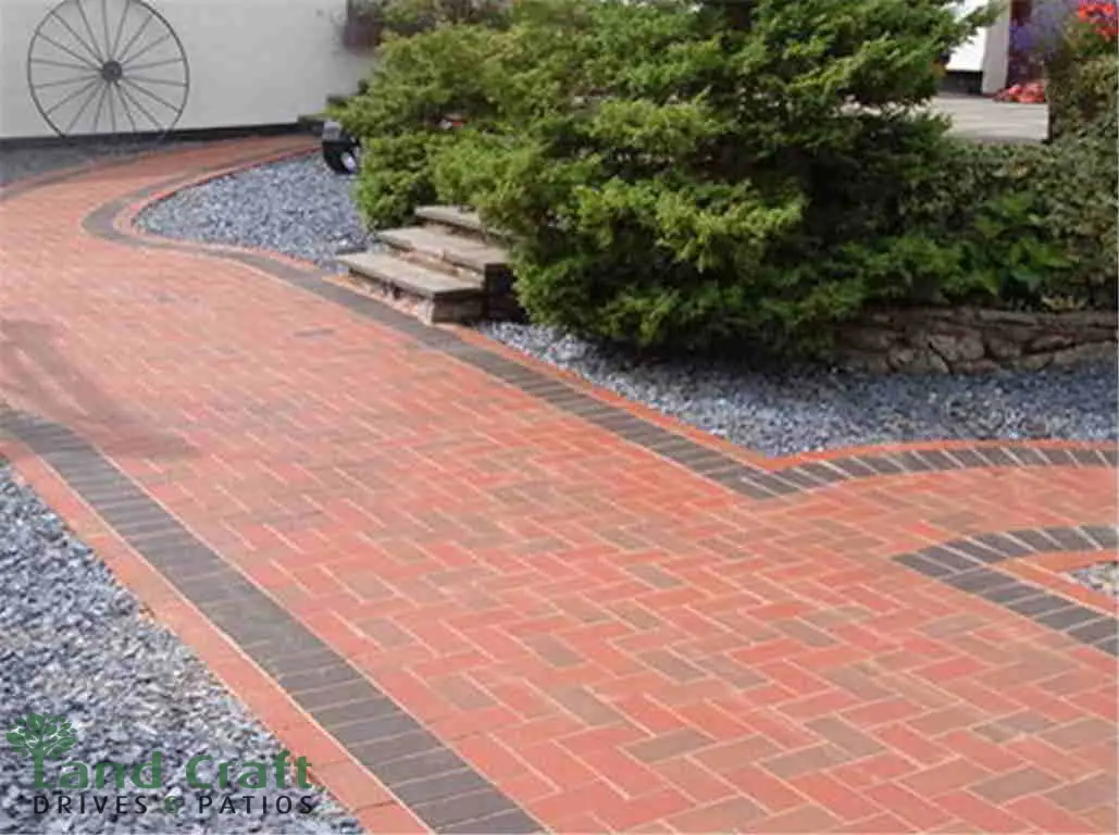 Red block paving with a charcoal pattern leading to a front door