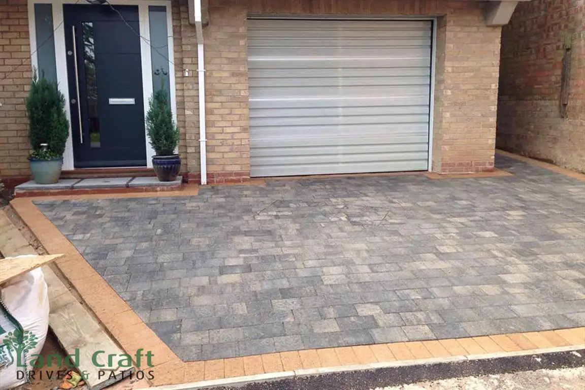 Grey block paved driveway in front of a garage