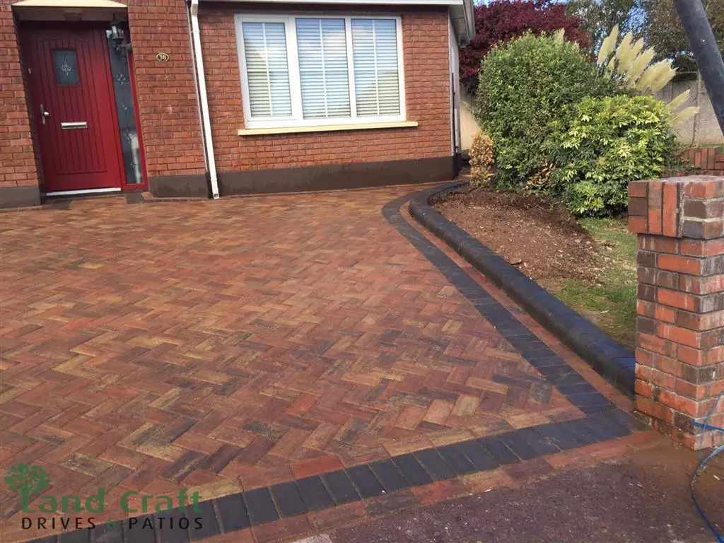 Red herringbone block paving driveway with a charcoal border