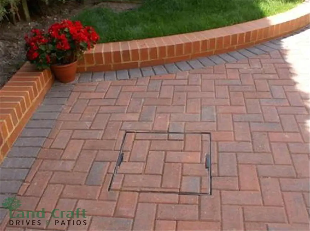 Red block paving with a curved brick planter