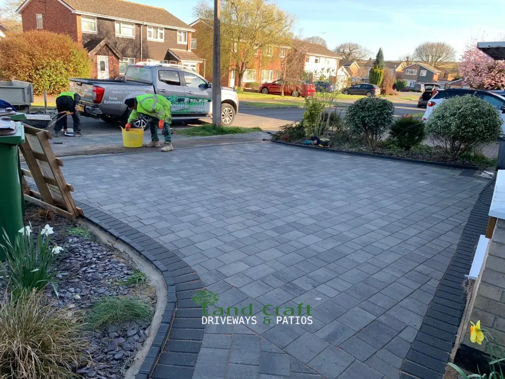 Charcoal block paved driveway curving past planting