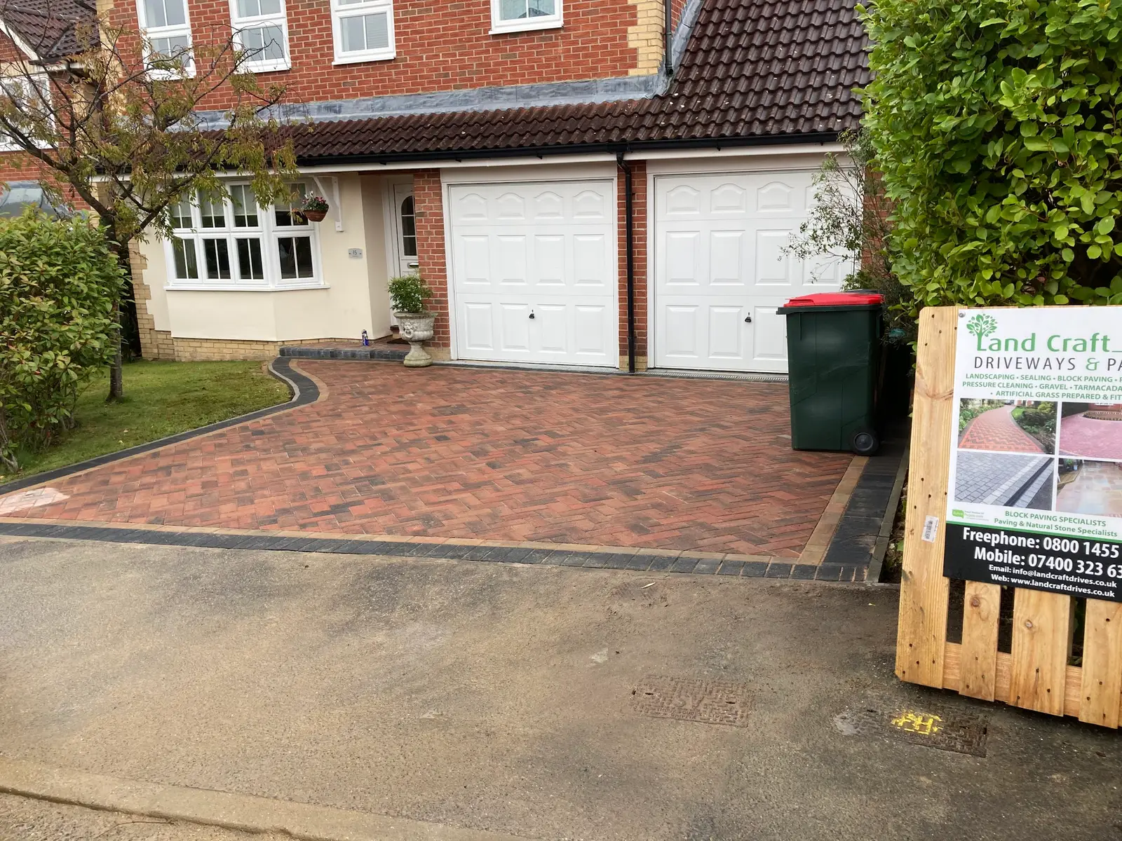 Red block paved driveway in front of a double garage