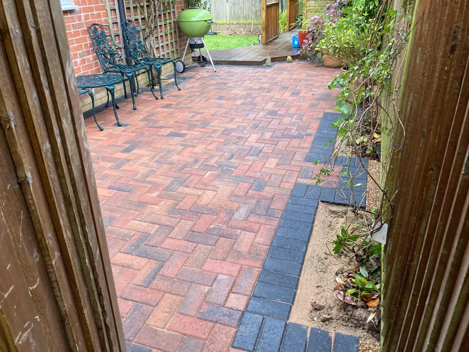Red herringbone block paving with a charcoal border