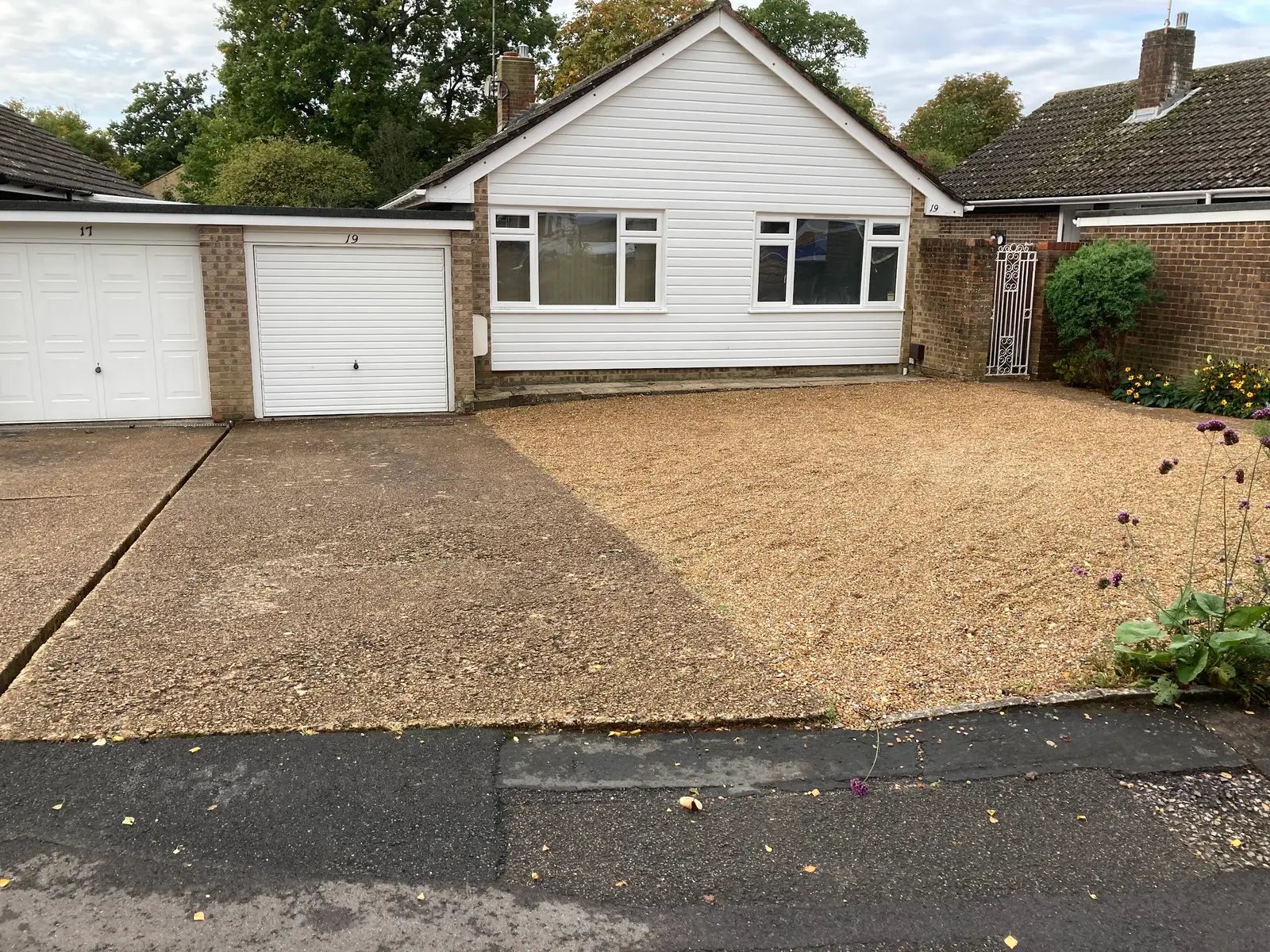 Gravel driveway in front of a bungalow with double garages