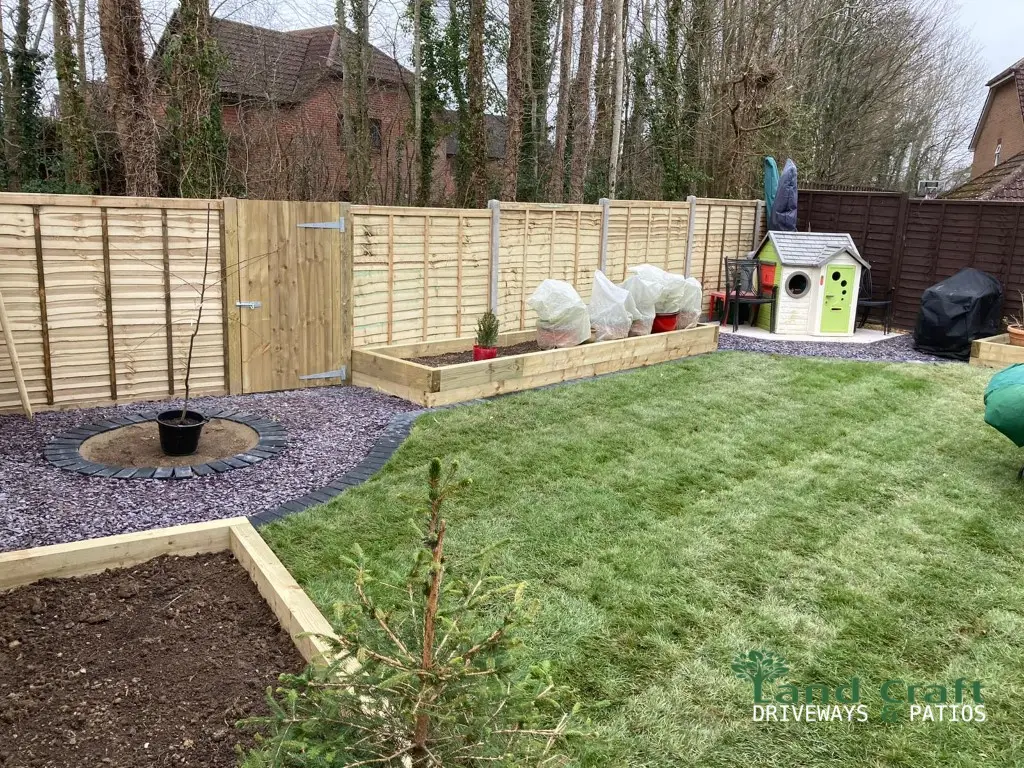 New timber fence panels around a garden with a lawn and raised bed