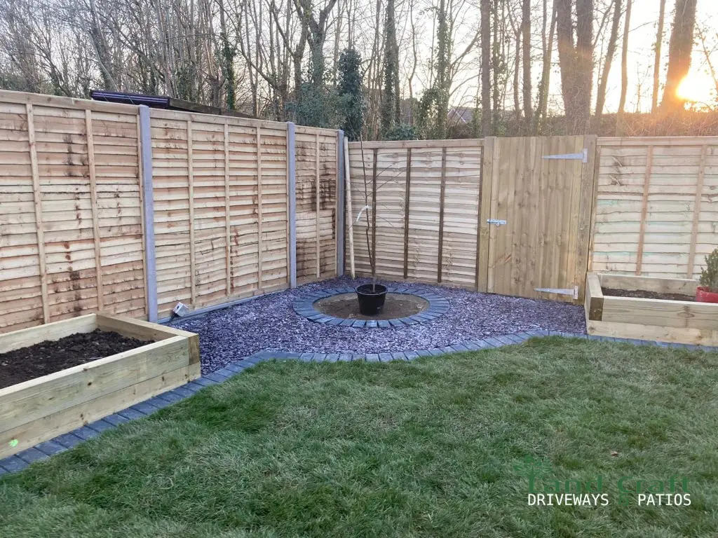 New timber fencing around a lawn with raised beds
