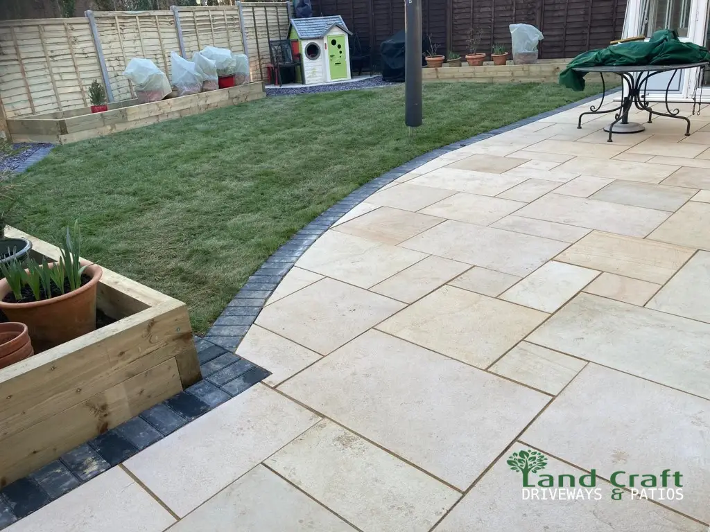 Buff porcelain patio beside a raised sleeper bed