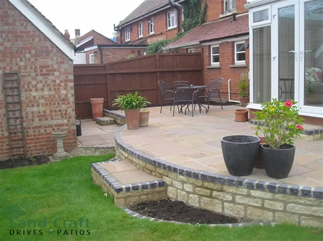 Raised curved patio with natural stone walling