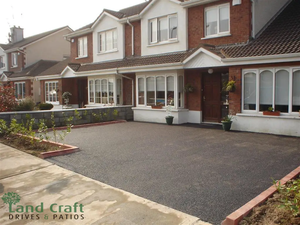 Tarmac driveway with a brick border in front of a detached house